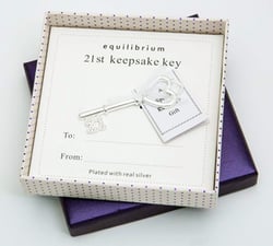 a silver key in a box that says equilibrium 21st keepsake key