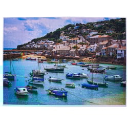 A picture of boats in a harbor with a small village in the background.