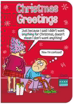 A cartoon of a woman standing next to a man on a couch with the words "Christmas greetings" at the top.