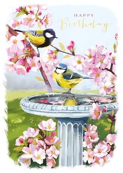 Two birds are sitting in a birdbath, surrounded by pink flowers.