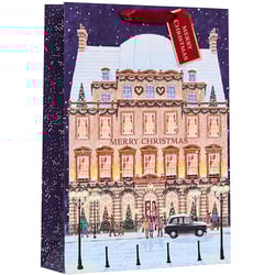 a merry christmas gift bag with a picture of a building