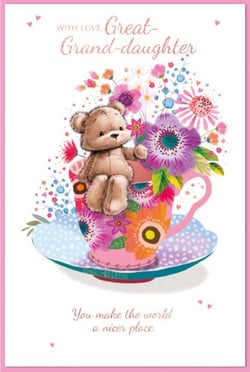 a teddy bear is sitting in a teacup with flowers .