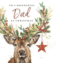 a christmas card with a deer with antlers decorated with leaves and berries .