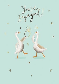 two geese are holding a diamond ring in their beaks .