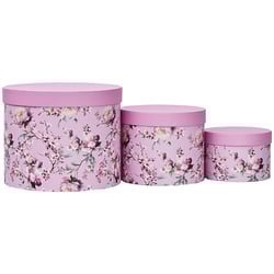 three pink boxes with white flowers on them