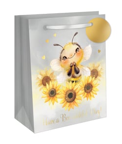 Present gifts with a touch of sunshine using our delightful Extra Large Bee-autiful Gift Bag. This charming design from Out of The Blue Studios Ltd. features an irresistibly cute bee, happily surrounded by vibrant sunflowers and sparkling golden hearts. The uplifting message, 'Have a Bee-autiful Day!', is elegantly foiled, adding a premium feel.

Perfect for larger presents, this spacious bag boasts a sturdy construction, complete with a luxurious ribbon handle and a matching golden gift tag. It's an ideal choice for birthdays, thank yous, or simply to spread a little joy. Stock up with our convenient 1x6 pack and offer your customers a truly 'bee-autiful' way to gift.