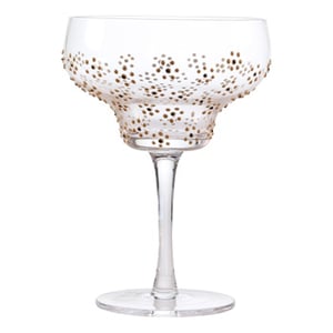 A clear wine glass with gold polka dots on it.