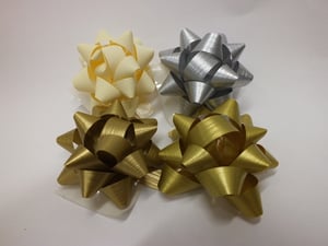 Gold and silver bows are on a white surface.
