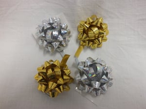 Four differently colored bows are on a white surface.