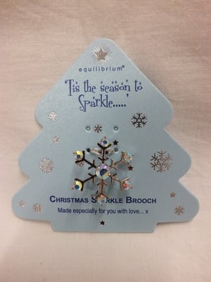 A Christmas sparkle brooch with a snowflake on it.