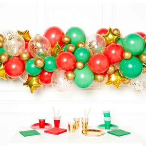 A table with red, green, and gold balloons on it.