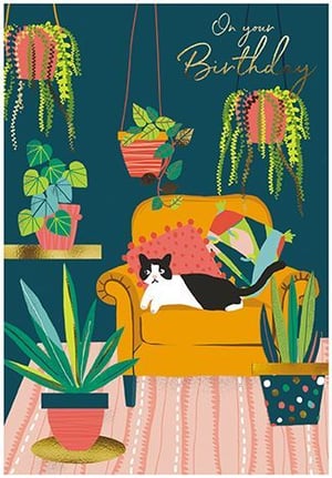 a black and white cat is laying on a yellow chair surrounded by potted plants .