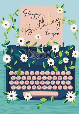 a birthday card with a typewriter surrounded by flowers and leaves .