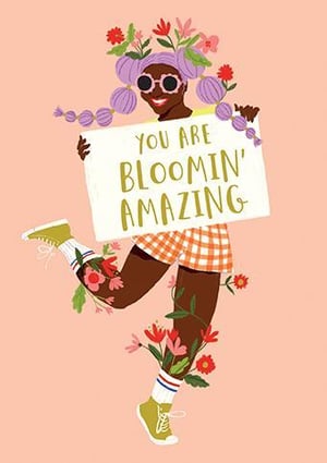 a woman with flowers in her hair is holding a sign that says `` you are bloomin ' amazing '' .