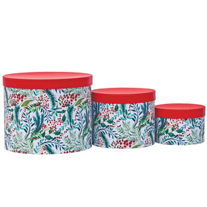 three round boxes with a floral design on them