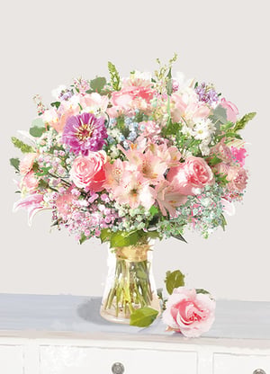 a vase filled with pink and purple flowers sits on a table