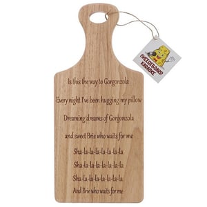a wooden cutting board with a tag that says cheeseboard karaoke