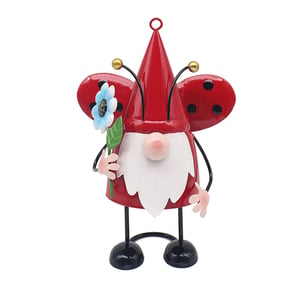a gnome with ladybug wings is holding a flower