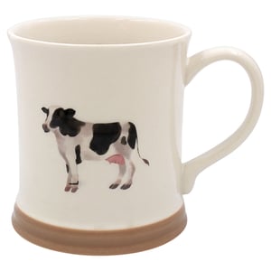 a white mug with a black and white cow on it