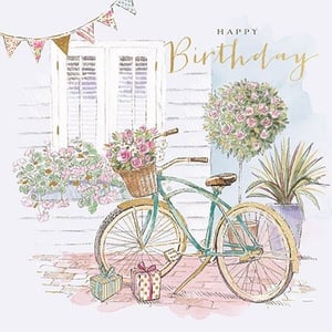 Introduce a touch of whimsical charm to your card selection with our 'Open Birthday Female' card. This exquisite design features a delightful vintage-style bicycle, its basket brimming with beautiful pink roses, set against a charming cottage backdrop. Golden 'Happy Birthday' script, delicate bunting, and potted greenery complete this idyllic scene, creating a truly special greeting. Perfect for celebrating any woman's birthday, its soft watercolour palette and intricate details make it a standout choice. Supplied by Ling, each pack contains 6 cards, ready to bring joy to your customers.