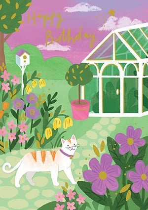 a cat is walking in a garden next to a greenhouse .