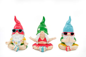 three gnomes wearing bikinis and sunglasses are sitting in a lotus position