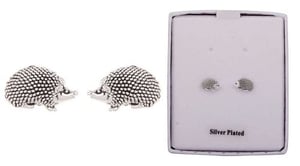 a pair of silver plated hedgehog stud earrings in a box .
