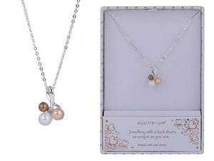 a necklace with three pearls on a chain in a box .