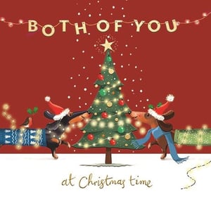 This charming "To Both Of You" Christmas card, supplied by Ling, is sure to be a customer favourite this festive season. Featuring two adorable dachshunds in their Santa hats and cosy jumpers, they are captured in the delightful act of decorating a twinkling Christmas tree. With a little robin friend perched on one dog's back, this heartwarming scene perfectly conveys warm wishes to a special couple. The playful design and festive colours make it an ideal choice for spreading holiday cheer. Available in a convenient 1x6 pack, these cards are ready to add a touch of joy and cuteness to your Christmas card display.
