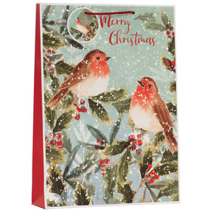 Bring festive cheer to your customers' gift-giving with our charming Extra Large Snowy Robins Gift Bag. This beautiful bag features an enchanting watercolour design of two adorable robins perched amongst snow-dusted holly and vibrant red berries, all set against a soft, wintry blue background. The elegant "Merry Christmas" message adds a classic touch.
Perfect for larger presents, its extra-large size ensures ample space for those special Christmas surprises. With sturdy red handles and a matching red side, this bag is both practical and wonderfully decorative. Supplied by Partisan Products Ltd., these delightful bags come in a convenient pack size of 1x6, making them an ideal addition to your seasonal stock.