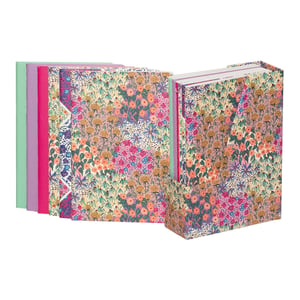 Introduce a burst of floral charm to your stationery collection with our 6 Liberty Garden A6 Notebooks With Stand from Partisan Products Ltd. This delightful set features six A6 notebooks, each adorned with a vibrant, intricate floral pattern that evokes the timeless beauty of a blooming garden. The colourful, patchwork-style designs in shades of pink, orange, green, and blue are sure to inspire creativity. Perfectly sized for notes, sketches, or journaling, these notebooks come neatly housed in a matching stand, making them a beautiful display piece for any desk or shelf. A wonderful gift idea or a treat for any stationery enthusiast, this single pack offers both practicality and exquisite style.