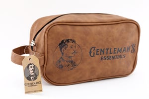 Introducing the Gentleman's Toiletry Bag, a stylish and practical essential for any discerning man. Crafted from rich brown faux leather, this bag exudes classic charm. It features a distinguished vintage illustration of a gentleman and the elegant "Gentleman's Essentials" branding, making it a sophisticated accessory.
Perfect for keeping grooming items organised at home or on the go, this single-pack toiletry bag combines timeless style with everyday functionality. Its sturdy design and convenient handle make it ideal for travel or daily use. A thoughtful gift or a personal treat, it's designed for the modern gentleman who appreciates quality and elegance.