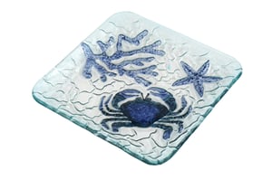 Bring a splash of seaside charm to any table with our delightful 20.5cm Crab Glass Plate. Crafted from clear, textured glass, this square plate features a beautifully embossed design of a vibrant blue crab, intricate coral, and a charming starfish. The subtle rippled surface adds to its aquatic appeal, making it a perfect addition for those who love coastal-inspired decor.
Ideal for serving appetisers, desserts, or simply as a decorative piece, this versatile plate instantly evokes sunny beach days. Its eye-catching design and durable construction make it a fantastic choice for gift shops, homeware stores, or anyone looking to add a unique touch to their collection. Available in a convenient pack of four, it's easy to stock up on this charming item.