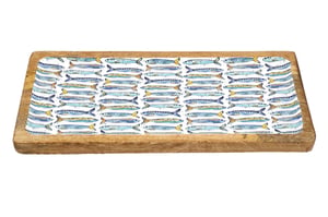 Introduce a splash of seaside charm with our 40cm x 19cm Wooden Sardines Enamel Tray. This beautifully crafted rectangular tray features a natural wooden base, complemented by a vibrant enamel insert. Adorned with an eye-catching pattern of blue and yellow sardines, it brings a fresh, coastal feel to any setting. Ideal for serving appetisers, drinks, or simply as a decorative centrepiece, its unique design makes it a versatile piece for your customers' homes. Each tray is supplied individually, offering a distinctive touch of nautical elegance.