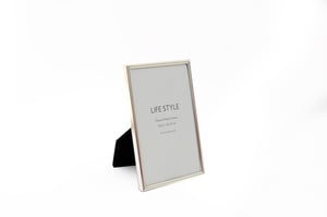 Showcase cherished memories in style with our elegant 6"x4" Silver Plated Edge Photo Frame. This classic frame features a sleek silver-plated edge, adding a touch of sophistication to any desk, shelf, or mantelpiece. Designed to hold standard 6x4 inch (10x15 cm) photographs, it's perfect for displaying family portraits, holiday snaps, or special moments. The sturdy design ensures your photos stand proudly, making it an ideal gift or a beautiful addition to any home decor collection. Supplied individually, these deluxe metal frames offer a timeless appeal that your customers will adore.