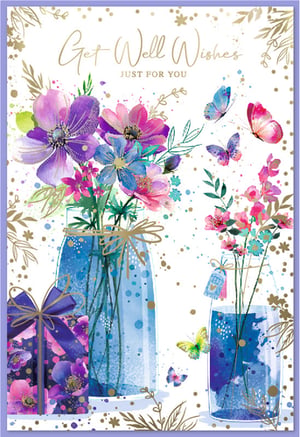 Brighten someone's day with our charming 'Get Well Female' card, brought to you by Simon Elvin. This exquisite design features a beautiful watercolour illustration, bursting with vibrant purple, pink, and blue flowers artfully arranged in stylish glass jars. Graceful butterflies flutter across the scene, adding a touch of delicate cheer. A thoughtfully wrapped gift box enhances the heartfelt message, all set against a clean white background adorned with elegant gold accents. With its warm 'Get Well Wishes Just For You' message, this card is perfect for sending uplifting thoughts. Stock up with our convenient pack of 6, a wonderful addition to your greeting card range.