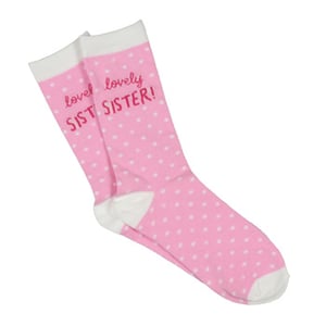 A pair of pink and white polka dot socks that say "lovely lovely sister".