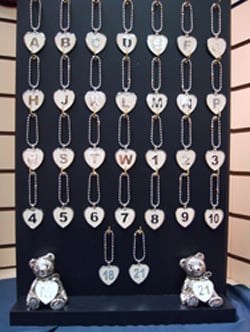 A display of necklaces with the letters A through N.