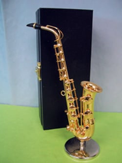 A saxophone is sitting on a table next to a black box.