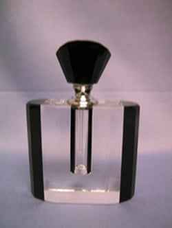 A clear glass perfume bottle with a black top.