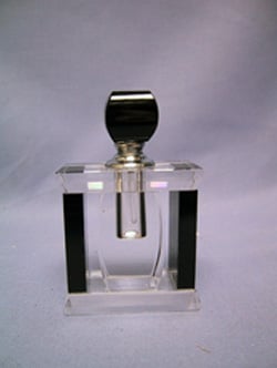 A clear glass perfume bottle with a black top.