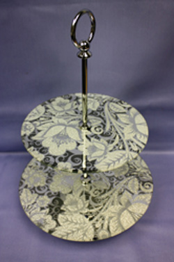 A cake stand with two plates and a silver handle.