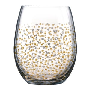 A clear glass with gold and silver polka dots is on it.