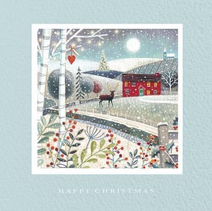 A Christmas card with a deer and a house in the background.