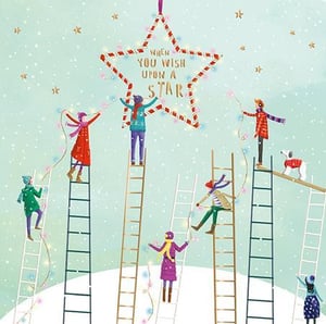 A group of people is climbing ladders to decorate a star.