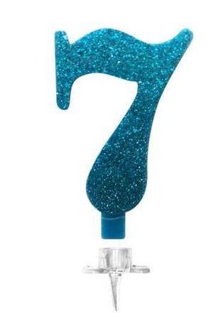 A blue glitter birthday candle in the shape of number seven on a white background.
