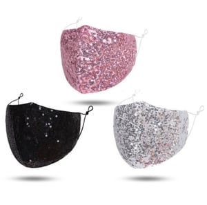 Three face masks with sequins are floating in the air.
