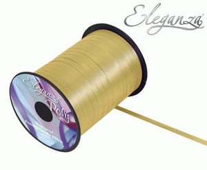 A spool of gold ribbon on a white background.