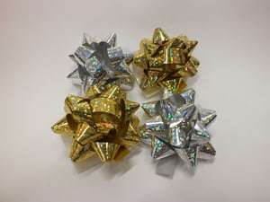 Gold and silver bows are on a white surface.
