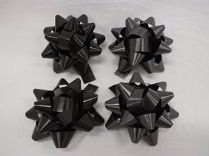 Four black bows is sitting on a white surface.